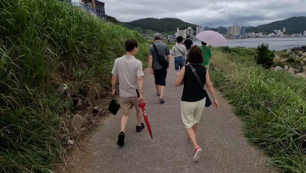바닷가 길을 걷는 친구들